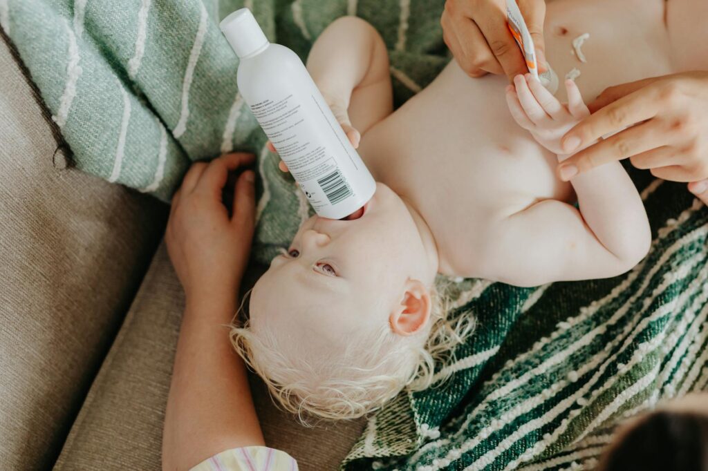 pexels-photo-8909871 a baby lying down while holding a plastic bottle