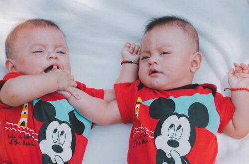 two babies wearing red mickey mouse shirts