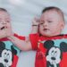 two babies wearing red mickey mouse shirts