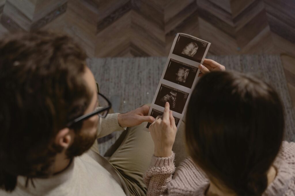 Couple looking at ultrasound images, excited for their upcoming baby.