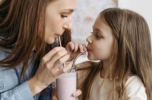 woman and child sharing a glass of milk shake